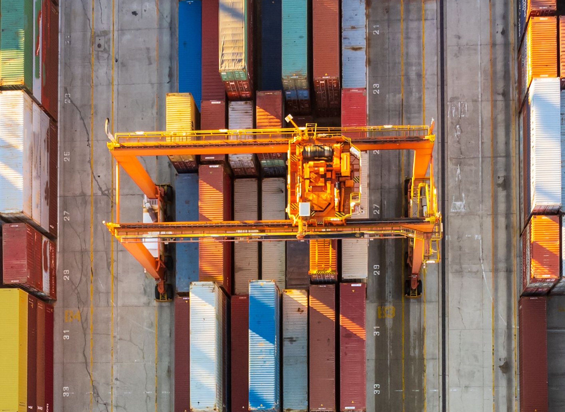 Aerial view of a gantry crane working shipping containers in a port container yard